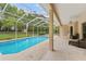 A tranquil pool is viewed from the covered patio, offering seamless indoor-outdoor living and entertaining at 12805 Coronado Dr, Spring Hill, FL 34609