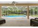 A serene view of the screened pool, with comfortable seating on the covered lanai, perfect for relaxation at 12805 Coronado Dr, Spring Hill, FL 34609