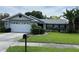 Charming single-story home with a two car garage, manicured lawn, and mature landscaping at 13316 Brigham Ln, Hudson, FL 34667