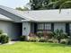 Well-maintained front yard with brick home, lush landscaping, and a manicured lawn at 13316 Brigham Ln, Hudson, FL 34667