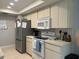 Kitchen with stainless steel refrigerator, white cabinets, microwave, oven, and tile flooring at 13316 Brigham Ln, Hudson, FL 34667