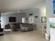 Spacious living room with high ceilings, tile floors, ceiling fan, and modern décor at 13316 Brigham Ln, Hudson, FL 34667