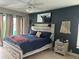 Tranquil main bedroom with ceiling fan, blue accent wall, and decorative artwork at 13316 Brigham Ln, Hudson, FL 34667