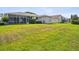 Expansive lawn leads to a screened lanai, offering seamless indoor-outdoor living at 13922 Talmage Loop, Hudson, FL 34667