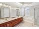Elegant bathroom featuring double sinks, tub, and arched windows with stylish shutters at 13922 Talmage Loop, Hudson, FL 34667
