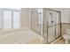 Well-lit bathroom with a bathtub, glass shower, shuttered window, and toilet at 13922 Talmage Loop, Hudson, FL 34667