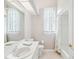 Well-lit bathroom featuring a vanity with a large mirror, toilet, and a shower-tub combination at 13922 Talmage Loop, Hudson, FL 34667