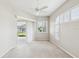 Bright bedroom with neutral carpet, sliding door access to backyard, and ample natural light through shuttered windows at 13922 Talmage Loop, Hudson, FL 34667