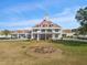 Inviting community building featuring manicured lawns, a clock tower and a welcoming American flag at 13922 Talmage Loop, Hudson, FL 34667