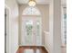 Inviting foyer featuring a decorative glass front door, high ceilings, and warm hardwood floors at 13922 Talmage Loop, Hudson, FL 34667