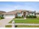 Inviting front exterior with well-manicured landscaping and a two-car garage at 13922 Talmage Loop, Hudson, FL 34667