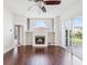 Bright living room with hardwood floors, fireplace, built-in shelves, and sliding glass doors to the patio at 13922 Talmage Loop, Hudson, FL 34667