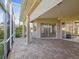 Covered screened patio with brick flooring, ceiling fan, and access to the living room through sliding glass doors at 13922 Talmage Loop, Hudson, FL 34667