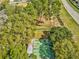 Aerial view of green shuffleboard courts nestled among trees, adjacent to a road at 13922 Talmage Loop, Hudson, FL 34667