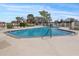 Community swimming pool offering residents a refreshing outdoor amenity with chairs and space at 13922 Talmage Loop, Hudson, FL 34667