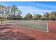 Outdoor tennis court with a net, showcasing community recreational amenities at 13922 Talmage Loop, Hudson, FL 34667