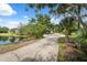 Long paved driveway with a view of the home and pond at 1471 N Jasmine Ave, Tarpon Springs, FL 34689