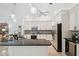 Well-lit kitchen featuring white cabinets, granite countertops, and modern stainless-steel appliances at 1471 N Jasmine Ave, Tarpon Springs, FL 34689