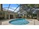 Screened-in pool and spa with covered patio, pillars and views of the backyard at 1471 N Jasmine Ave, Tarpon Springs, FL 34689