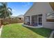 Green backyard with a screened-in porch and rock landscaping at the base of the house at 1862 Wood Bend St, Tarpon Springs, FL 34689