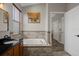 Bathroom featuring a soaking tub, tiled walls, and a single sink vanity at 1862 Wood Bend St, Tarpon Springs, FL 34689