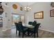 Bright dining room with a glass-top table, seating for six, stylish chandelier, and sliding door access to the backyard at 1862 Wood Bend St, Tarpon Springs, FL 34689