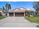 Well-maintained single-story home featuring a spacious driveway leading to a two-car garage and a meticulously kept front lawn at 1862 Wood Bend St, Tarpon Springs, FL 34689