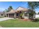 Charming single-story home with a well-manicured lawn, mature landscaping, and a two-car garage on a sunny day at 1862 Wood Bend St, Tarpon Springs, FL 34689