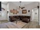 Cozy living room featuring a plush leather sectional sofa, a decorative ceiling fan, and tile flooring with an area rug at 1862 Wood Bend St, Tarpon Springs, FL 34689