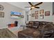 Open-concept living room with a comfortable leather sectional sofa, ceiling fan, and tile floors for easy maintenance at 1862 Wood Bend St, Tarpon Springs, FL 34689