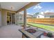 Tiled and covered patio, complete with a modern fire pit, overlooks the beautifully landscaped backyard at 1862 Wood Bend St, Tarpon Springs, FL 34689