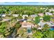 Bird's-eye view of a home with a screened-in pool, surrounded by mature trees and neighboring houses at 2172 Whitewood Ave, Spring Hill, FL 34609