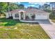 Charming single-story home features a well-manicured front yard, arched windows, and attached two-car garage at 2172 Whitewood Ave, Spring Hill, FL 34609