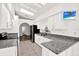 Modern kitchen with stainless steel appliances, granite countertops, and white cabinetry at 2172 Whitewood Ave, Spring Hill, FL 34609