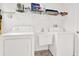 Functional laundry room featuring a washer, dryer, and utility sink, equipped for all laundry needs at 2172 Whitewood Ave, Spring Hill, FL 34609