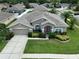 Stunning aerial view of a single-story home with lush landscaping, and a well manicured lawn at 22316 Red Jacket Ln, Land O Lakes, FL 34639