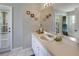 Well-lit bathroom with a white vanity, decorative mirror, and a doorway to the exterior at 22316 Red Jacket Ln, Land O Lakes, FL 34639