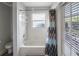 Bright bathroom featuring a white tub with a shower and a colorful shower curtain at 22316 Red Jacket Ln, Land O Lakes, FL 34639