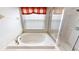 Close-up on a luxurious soaking tub with a glass shower and a window at 22316 Red Jacket Ln, Land O Lakes, FL 34639