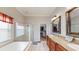 Bright bathroom showcasing a double vanity, glass shower, soaking tub, and walk-in closet at 22316 Red Jacket Ln, Land O Lakes, FL 34639