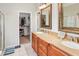 Well-lit bathroom featuring double vanity, a walk-in shower, and an adjacent walk-in closet at 22316 Red Jacket Ln, Land O Lakes, FL 34639