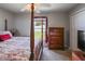 This bedroom features a ceiling fan, a four-poster bed, a dresser, and window at 22316 Red Jacket Ln, Land O Lakes, FL 34639