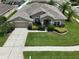 Charming single-story home with a two-car garage, lush landscaping, and a freshly manicured lawn at 22316 Red Jacket Ln, Land O Lakes, FL 34639