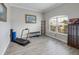 Flex room offers wood-look flooring, gray walls, a large window, and exercise equipment at 22316 Red Jacket Ln, Land O Lakes, FL 34639