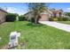 Beautiful single-Gathering home featuring a well-manicured lawn, mature trees, and a two-car garage at 22316 Red Jacket Ln, Land O Lakes, FL 34639