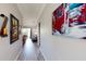 Hallway features hardwood floors and leads to a living area, enhanced by decorative wall art at 22316 Red Jacket Ln, Land O Lakes, FL 34639