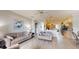 Open floor plan with the living room featuring wood floors, neutral paint, and a view of the kitchen at 22316 Red Jacket Ln, Land O Lakes, FL 34639