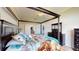 Spacious main bedroom featuring a four-poster bed, ensuite bathroom, and walk-in closet at 22316 Red Jacket Ln, Land O Lakes, FL 34639