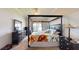 Well-lit main bedroom featuring a four-poster bed, carpeted floors, and a bright window at 22316 Red Jacket Ln, Land O Lakes, FL 34639