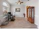 The home office offers wood-look flooring, gray walls, a display case, and a large sunny window at 22316 Red Jacket Ln, Land O Lakes, FL 34639